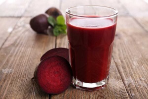 glass of beet juice with beets