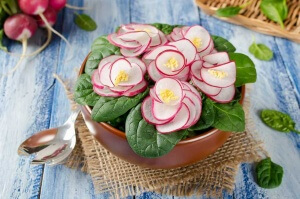 salad with flowers from radish and spinach leaves